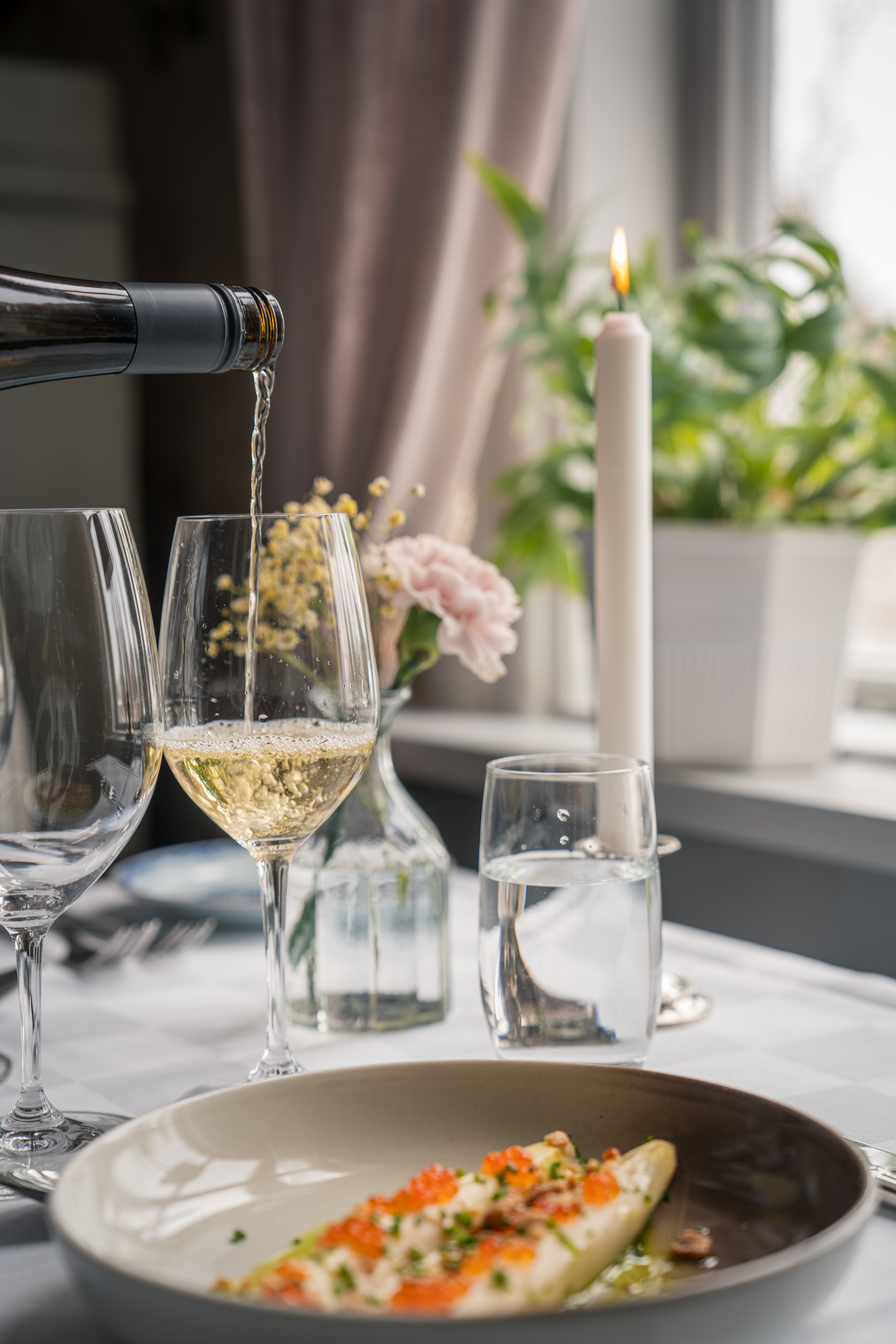 Vit sparris serveras med ett glas champagne