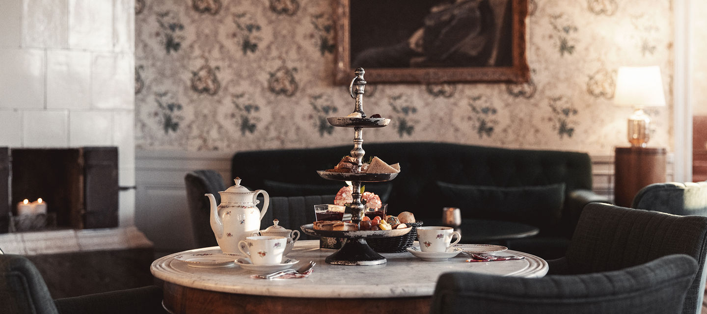 Bord dukat för afternoon tea, kakfat och vackra tekoppar