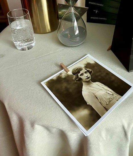 På ett bord ligger ett gammalt svartvitt foto på en ung kvinna 