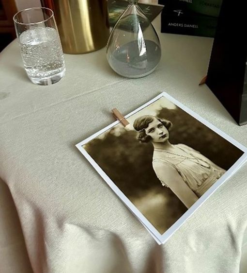 På ett bord ligger ett gammalt svartvitt foto på en ung kvinna