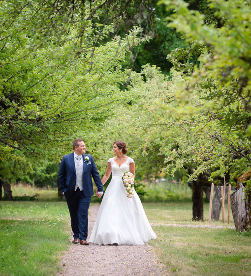 Brudpar går genom trädgården