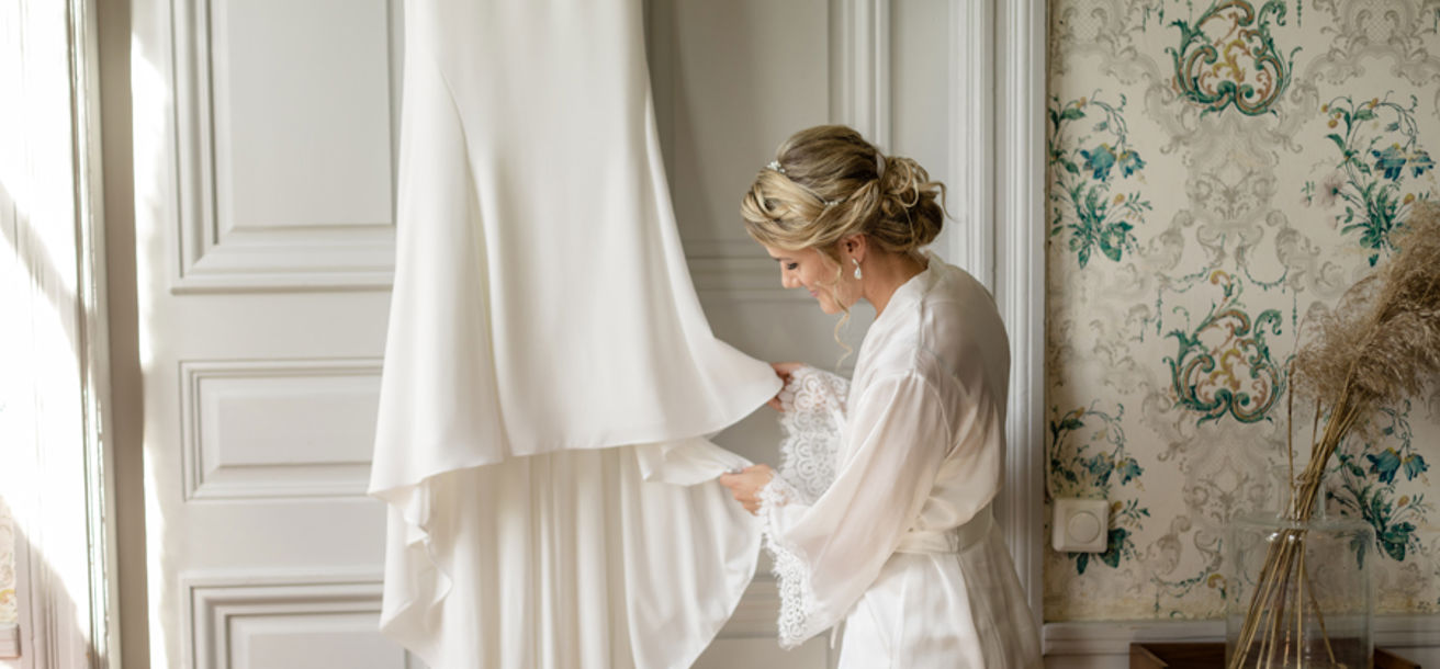 Brud tittar på sin brudklänning