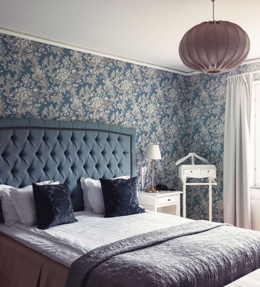 Rymligt hotellrum med blommig tapet