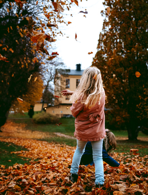 Barn leker i lövhög