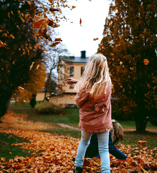 Barn leker i lövhög