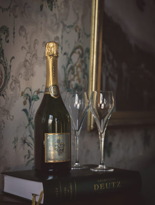 Champagneflaska och två glas i vacker salong på en herrgård