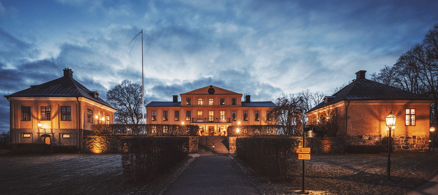 Herrgården upplyst av lampor på hösten