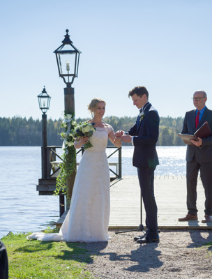 Bröllopspar blir vigda vid herrgårdens brygga vid Mälaren