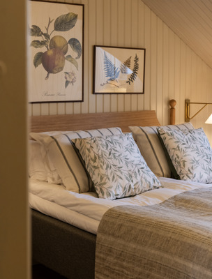 Bäddad säng med vackra prydnadskuddar i herrgårdsstil