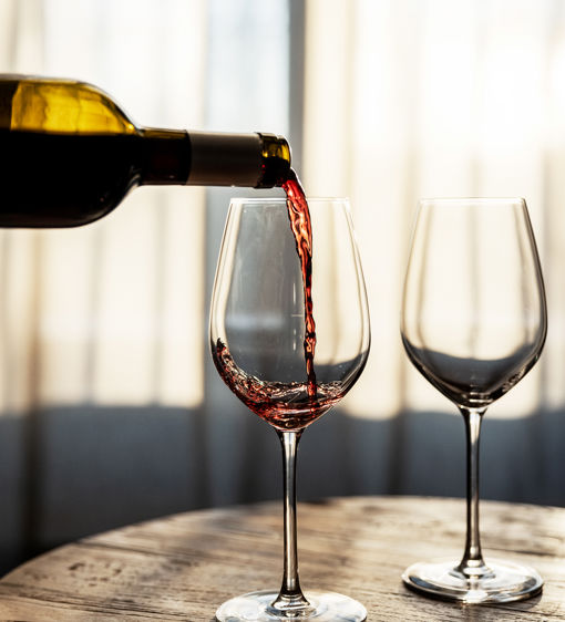 Rödvin hälls upp i vinglas