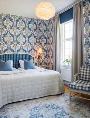 Mjuk säng i sovrum med blåa detaljer