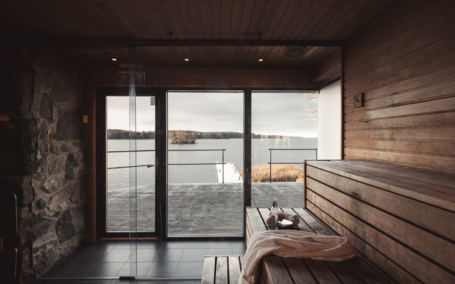 Vedeldad bastu med stora glasfönster och utsikt över Mälaren