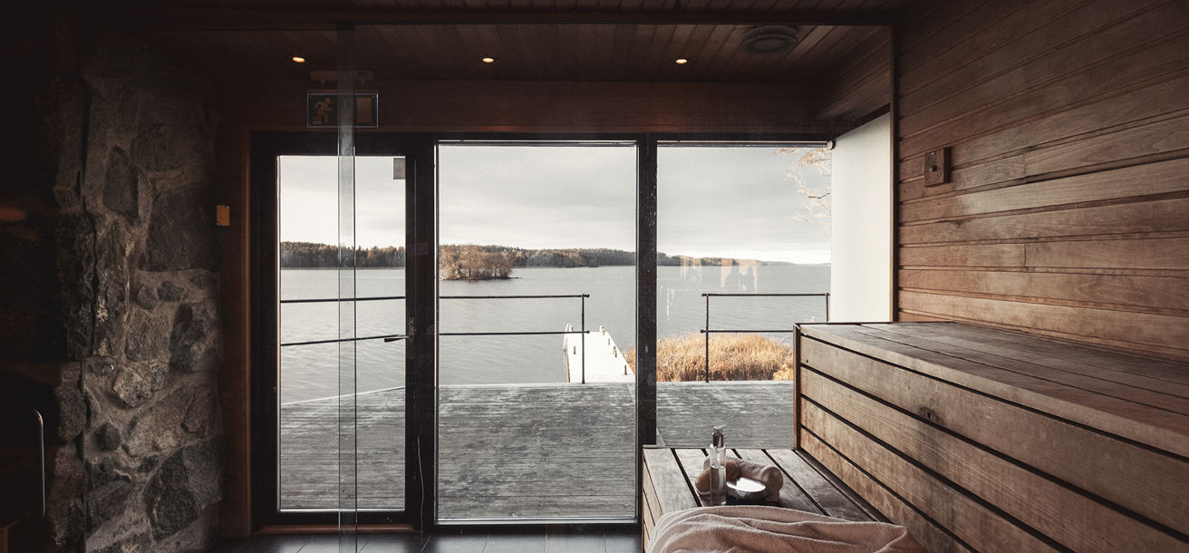 Vedeldad bastu med stora glasfönster och utsikt över Mälaren