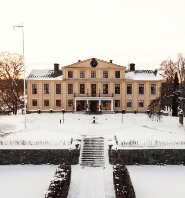 Herrgårdsbyggnaden i vinterskrud med snö