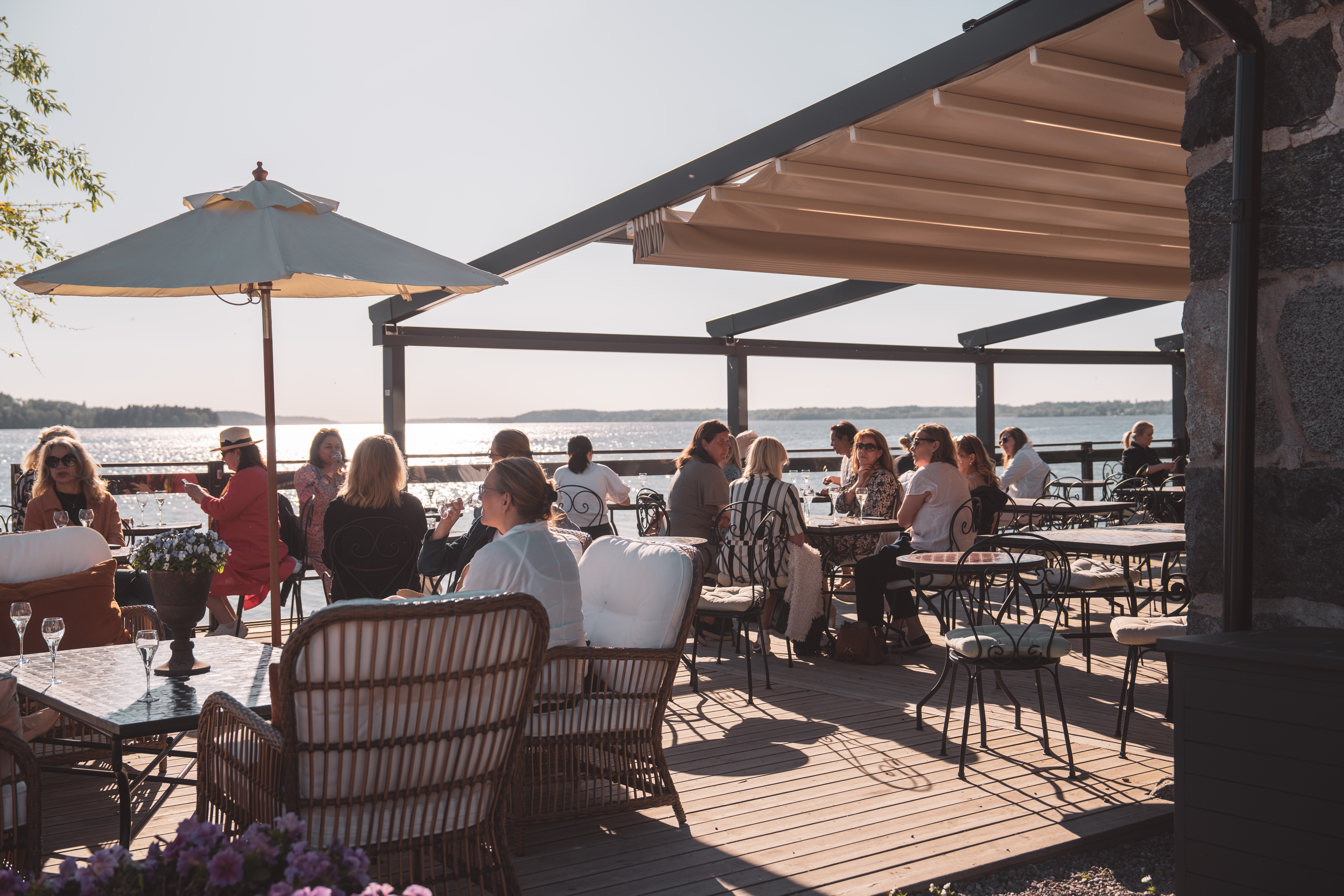 Solig uteterrass med människor 