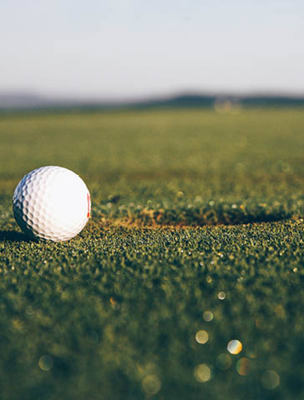 Golfboll i grönt gräs