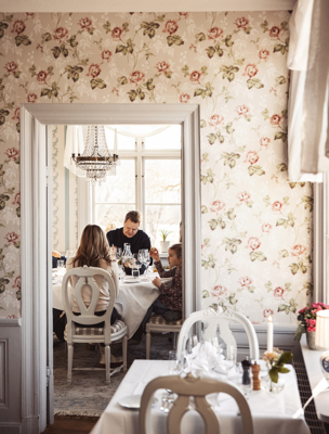 Familj äter middag i en av herrgårdens salonger