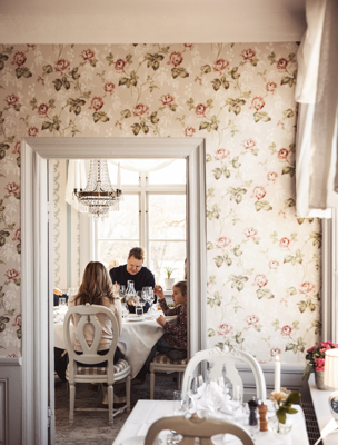 Familj äter middag i en av herrgårdens salonger