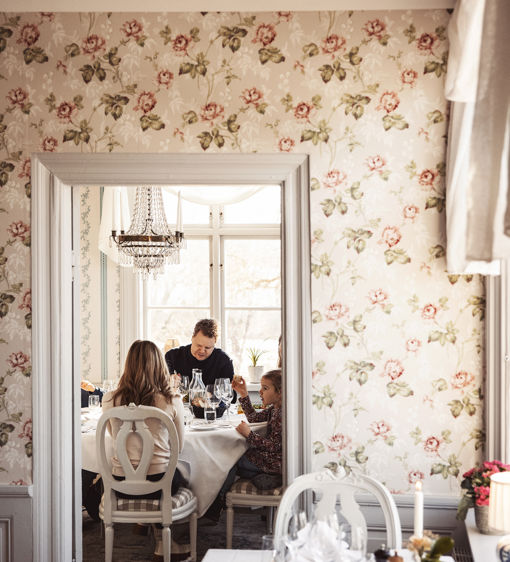 Familj äter middag i en av herrgårdens salonger