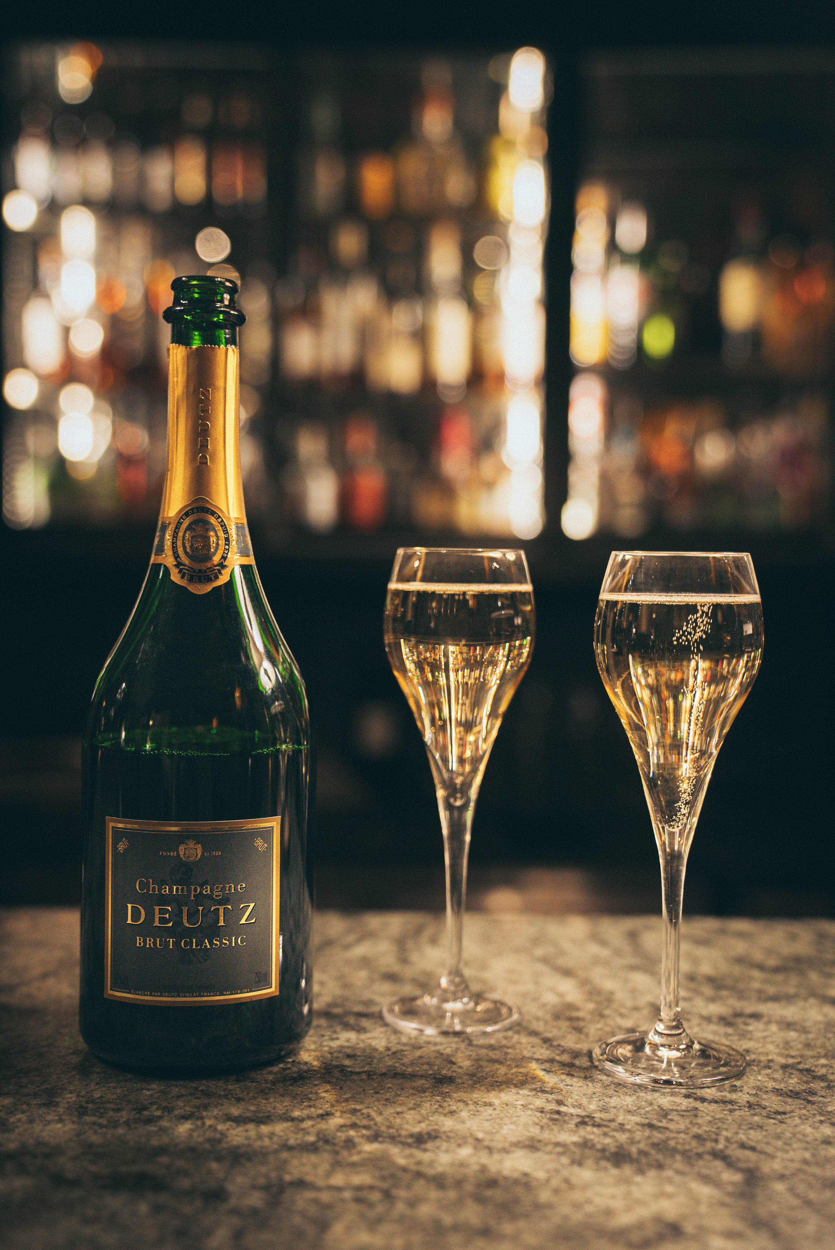 Champagneflaska och två upphällda champagneglas